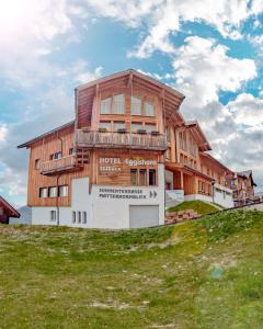 uma casa de madeira no topo de uma colina em Hotel Eggishorn em Fiesch