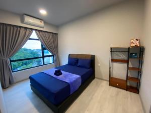 een slaapkamer met een blauw bed en een raam bij KK City Jesselton Quay near Suria Mall by JR Homestay in Kota Kinabalu