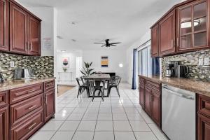 a kitchen with wooden cabinets and a table in it at Spacious 4BRS Home, Relax Backyard close to Casino in Hollywood