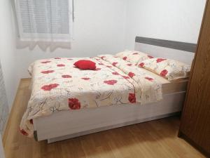 a bedroom with a bed with red flowers on it at APARTMAJI VALTER in Srpenica