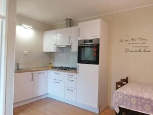 a kitchen with white cabinets and a stove top oven at APARTMAJI VALTER in Srpenica
