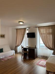 a bedroom with a desk and a bed and a bed and a desk at Pensiunea Central Sibiu in Sibiu