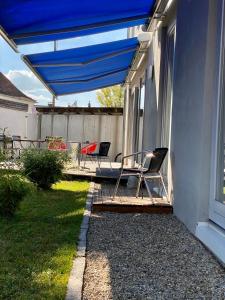 a patio with two chairs and a blue umbrella at Hotel Sonderborg in Schrobenhausen