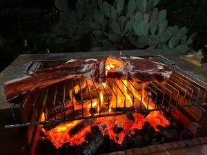 Ein Stück Fleisch kocht auf einem Grill in der Unterkunft Casetta di campagna da Enzo in Rilievo