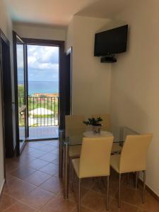 a dining room with a table and chairs and a television at Casa Miraflores in Cefalù