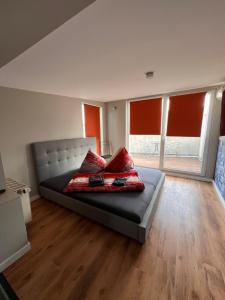 Un dormitorio con una cama con almohadas rojas. en Schillers Terrassen Fewo en Cottbus