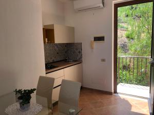 a kitchen with a table and chairs and a window at Casa Miraflores in Cefalù