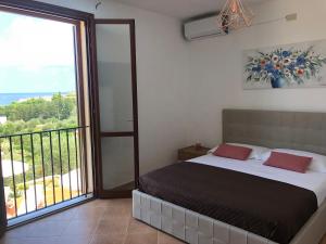 a bedroom with a bed and a large window at Casa Miraflores in Cefalù