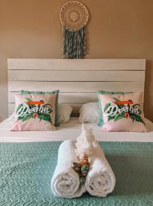 een bed met een handdoek en kussens erop bij Casa di Caribe - tropical beach in Willemstad
