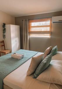 een slaapkamer met 2 kussens op een bed met een raam bij Casa di Caribe - tropical beach in Willemstad