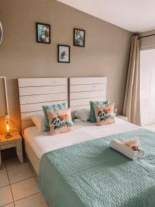 een slaapkamer met 2 aparte bedden en kussens bij Casa di Caribe - tropical beach in Willemstad