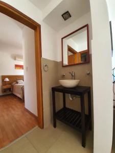 une salle de bain avec un lavabo et un miroir sur un mur dans l'établissement Arena de Mar Dpto B, à Las Gaviotas 13 autres photos