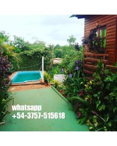 a garden with a swimming pool in front of a house at Complejo Remitur in Puerto Iguazú