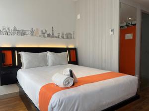 a bed in a bedroom with a white bedspread at easyHotel Lisbon in Lisbon