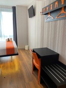 um quarto com uma cama, uma secretária e uma cama em easyHotel Lisbon em Lisboa