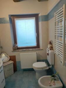 a bathroom with a toilet and a window at Casa Vacanze Al Molino in Brischis