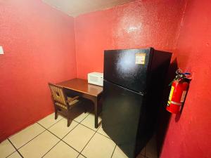 a small kitchen with a black refrigerator and a table at Royal Palms Motel in New Orleans