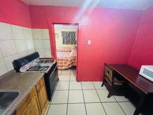 een keuken met een fornuis en een rode muur bij Royal Palms Motel in New Orleans
