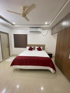 a bedroom with a large bed and a ceiling fan at Ameya Homestays Brand New Fully Furnished 3BHK & 2BHK Apartments. in Tirupati