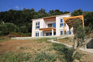a large white house on a hill with trees at Sunset Sea View Villa 8 in Afionas
