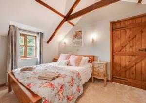 a bedroom with a bed and a wooden door at Hafod y Llwynog in Cross Inn