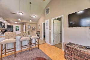 a living room with a kitchen and a bar with stools at Cozy Pantego Cottage about 5 Miles to Belhaven! in Pantego