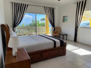 ein Schlafzimmer mit einem Bett und einem großen Fenster in der Unterkunft Spring Garden Mobay Resort Luxurious Apartments in Montego Bay