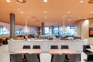 a restaurant with pink and black chairs and a counter at prizeotel Vienna-City in Vienna