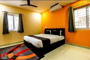 a bedroom with a bed with an orange wall at HOTEL SRIRAMA EMPIRE in Hyderabad