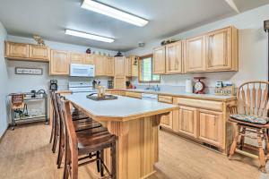 a kitchen with wooden cabinets and a large island at Cabin with Hot Tub, By Crater Lake Natl Park! in Klamath Falls