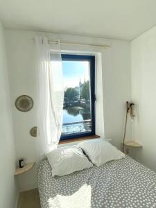 1 dormitorio con cama y ventana con vistas en Quimper: T3 avec vue cathédrale proche gare, en Quimper