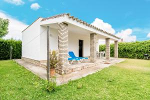 埃爾帕爾馬的住宿－El Madroño，一座白色的小房子,在院子里设有蓝色椅子