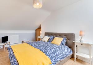 a bedroom with a bed with a blue and yellow blanket at Bryn Triban in Llanddyfnan