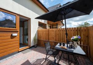 a patio with a table and an umbrella at Bryn Triban in Llanddyfnan