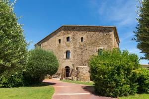 an old stone building with trees in front of it at Es Portal Restaurant i Hotel Boutique - Adults only in Pals