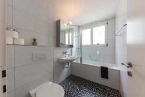 a white bathroom with a sink and a toilet at Joe's Apartment am Bolgen in Davos +9 photos