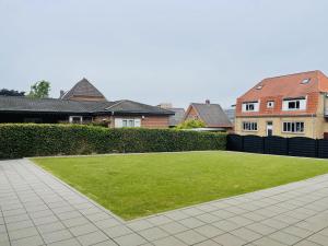 ein großer Rasenhof mit Häusern im Hintergrund in der Unterkunft aday - Charming loft studio in Aalborg