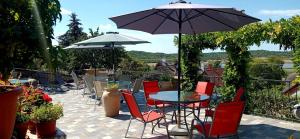 a patio with a table and chairs and an umbrella at T.H.NY Village Inn Cottage in Tihany