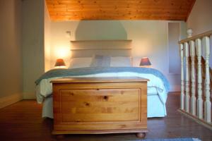 a bedroom with a bed with a wooden dresser and two lamps at Remarkable Apartment in Kenmare Ireland in Kenmare