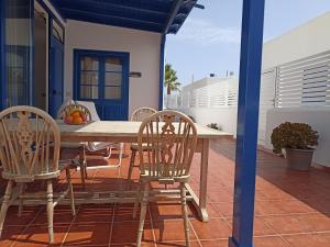 einen Holztisch und Stühle auf einer Terrasse in der Unterkunft Casa Rosa in Puerto Calero