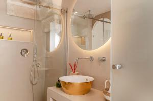 a bathroom with a bowl sink and a shower at Apulia Charming Suites - Casa Rossa Suite Perla e Suite Corallo in Savelletri di Fasano