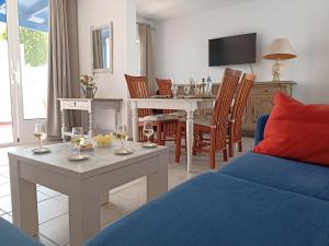 a living room with a couch and a table with wine glasses at Casa Rosa in Puerto Calero