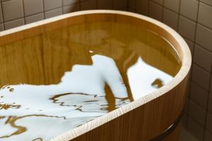 una vasca da bagno con il riflesso di un ratto bianco in acqua di Craft Inn Te a Yame