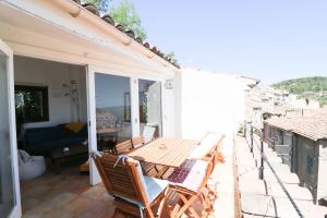 a patio with a wooden table and chairs on a house at Marie à Callas in Callas