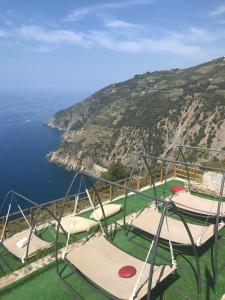 a row of picnic tables on a hillside overlooking the ocean at Il Borgo Di Campi in Riomaggiore
