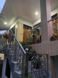een huis met een trap met potplanten erop bij Happy Homestay Sittong in Mangpu
