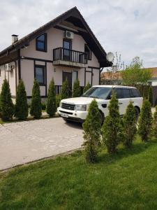 une voiture blanche garée devant une maison dans l'établissement Guest House on Lesnaya, à Leski