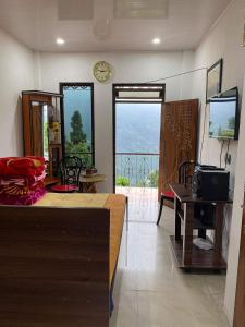 a bedroom with a bed and a balcony with a view at Happy Homestay Sittong in Mangpu