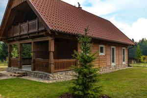 a log cabin with a large porch and a deck at Apartament w Bukowej Chacie in Mörken