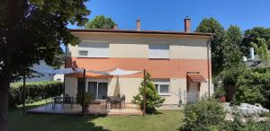 a house with a table and chairs in the yard at Holiday house Riviera - Balaton - Siófok in Siófok